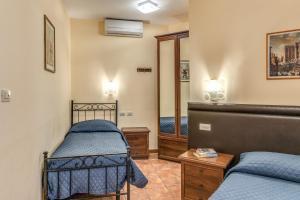 a bedroom with two beds and a mirror at Locanda San Cosimato in Rome