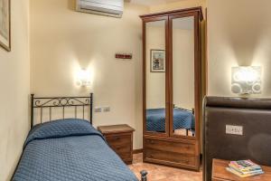 a bedroom with a bed and a mirror at Locanda San Cosimato in Rome