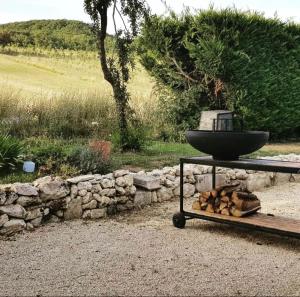 a fountain sitting on a table next to a stone wall at La Maison Or Azur- Spa Jacuzzi- Terrasse - Vue Nature in Penne-dʼAgenais