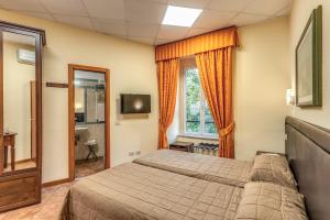 a bedroom with a bed and a tv and a window at Locanda San Cosimato in Rome