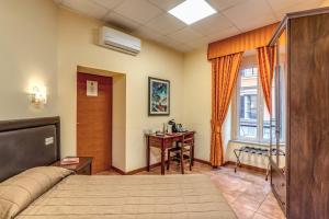a bedroom with a bed and a desk and a window at Locanda San Cosimato in Rome
