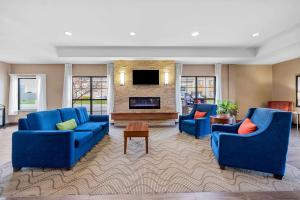 a living room with two blue couches and a fireplace at Comfort Inn & Suites West - Medical Center in Rochester