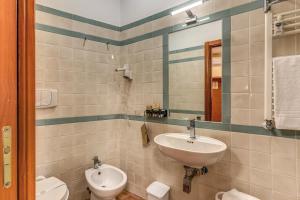 a bathroom with a sink and a toilet and a mirror at Locanda San Cosimato in Rome