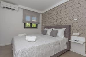 ein Schlafzimmer mit einem großen weißen Bett mit einem Fenster in der Unterkunft Villa VlD - Amazing holiday home! - Makarska Exklusiv in Makarska + 24 Fotos