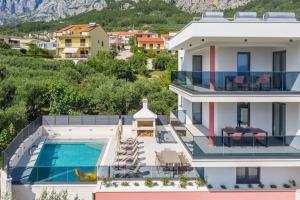 eine Villa mit Swimmingpool und ein Haus in der Unterkunft Villa VlD - Amazing holiday home! - Makarska Exklusiv in Makarska