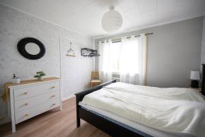 a bedroom with a bed and a dresser and a window at The bear's den in Håkafot