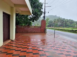 a brick sidewalk with a building and a street at Mangrove Ecostay in Gokarna