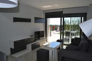 uma sala de estar com um sofá e uma televisão em ROMERO APARTMENTS-ARENALES DEL SOL em Arenales del Sol