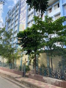 a building with a fence and trees in front of it at Budget friendly Mini Heaven 2 in Kolkata +22 photos