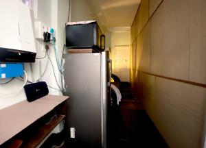 a small kitchen with a refrigerator with a tv on top at Budget friendly Mini Heaven 2 in Kolkata