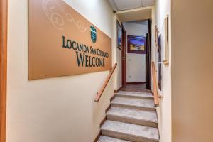 a staircase in a hallway with a welcome sign on the wall at Locanda San Cosimato in Rome