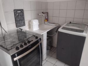 a small kitchen with a stove and a sink at Kitnet simples prox do Centro da Cidade in Caruaru