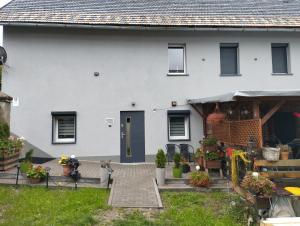 a white house with a door and a patio at Wiejsko-Sielsko in Szczytna