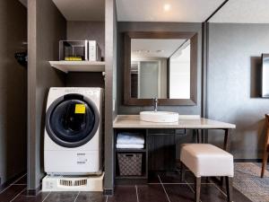 a washer and dryer in a bathroom with a sink at Tokyu Stay Hakata in Fukuoka