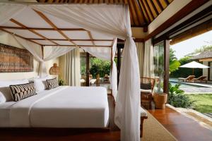 ein Schlafzimmer mit einem weißen Bett mit Himmelbett in der Unterkunft Villa Nelayan by Nakula in Canggu + 35 Fotos