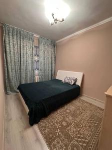a bedroom with a bed in the corner of a room at 3х комнатная по Толе би in Taraz
