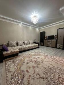 a large living room with a couch and a rug at 3х комнатная по Толе би in Taraz
