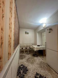 a kitchen with a refrigerator and a table and chairs at 3х комнатная по Толе би in Taraz