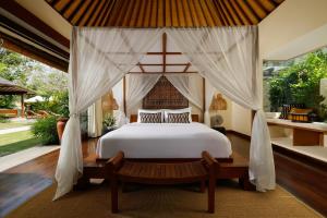 ein Schlafzimmer mit einem Himmelbett in der Unterkunft Villa Nelayan by Nakula in Canggu