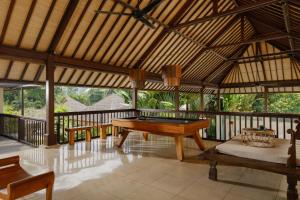 einen Pavillon mit einem Billardtisch auf einer Terrasse in der Unterkunft Villa Nelayan by Nakula in Canggu