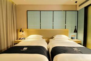 Voodi või voodid majutusasutuse Echarm Hotel Yulin Second People's Hospital Qingwanjiang Park toas