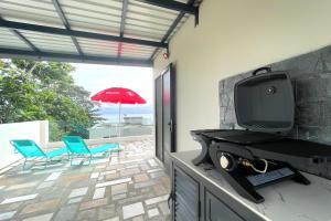 a living room with a tv and a patio at Baywatch - Pieds dans l'eau avec piscine in Baie du Tombeau