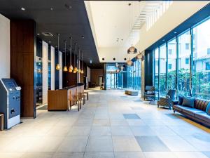Un vestíbulo de un edificio con sofás y ventanas. en Tokyu Stay Hakata, en Fukuoka