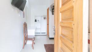 a door to a room with a chair and a desk at RedDoorz @ Lualhati Garden Cottage El Nido Palawan in El Nido