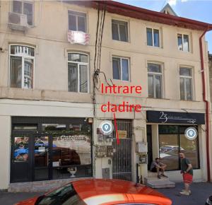 un'auto arancione parcheggiata davanti a un edificio di Blue Haven Studio, Rezerva acum studio cu Design Interior pe comanda, Incalzire Pardoseala, Apa filtrata, Cafea, Ceai, Parcare publica Gratuita a Craiova