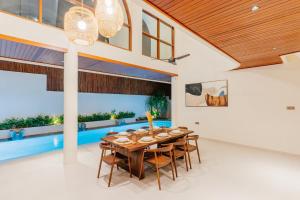 a dining room with a wooden table and chairs at Luxury Villa Noah - Walkable to Shopping Mall & Waterbom Bali in Kuta