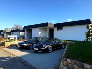 two black cars parked in front of a house at Ferienhaus Jordsand in Schausende