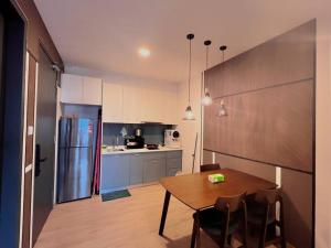 eine Küche mit Holztisch und Kühlschrank in der Unterkunft 5PX, 3BR Emporis KD, Near Segi & Thomson Hospital in Petaling Jaya
