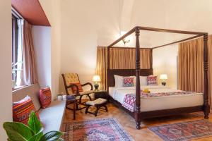 a bedroom with a canopy bed and a chair at amã Stays & Trails Lotus Dhauj , Haryana in Faridabad +36 photos