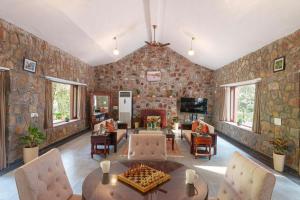 a living room with a stone wall at amã Stays & Trails Lotus Dhauj , Haryana in Faridabad