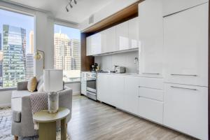 a kitchen with white cabinets and a table and a chair at Rincon Hill 1BR w WD Gym Pool nr Tech HQs SFO-784 in San Francisco