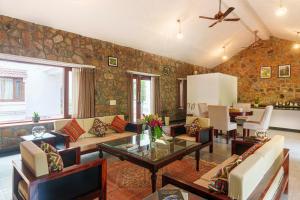 a living room with a couch and a table at amã Stays & Trails Lotus Dhauj , Haryana in Faridabad