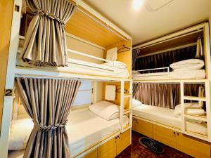 una habitación con tres literas en una casa en Charming Hostel, en Bangkok