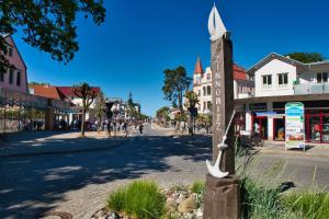 a street in a small town with a wooden cross at Ferienhaus Waldheide in Zempin