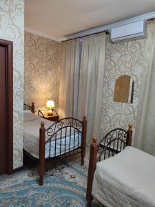 a bedroom with two twin beds and a window at Hostel Viator in Almaty