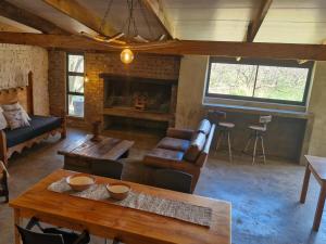 a living room with a couch and a table at Merwespont Guesthouses#DieHouthuis#Die Wyntenke#A Snoozer's Cottage# in Bonnievale