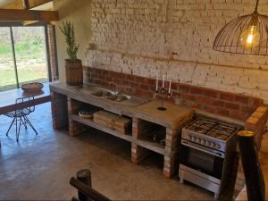a kitchen with a counter and a stove and a sink at Merwespont Guesthouses#DieHouthuis#Die Wyntenke#A Snoozer's Cottage# in Bonnievale +34 photos