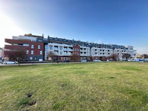 a large building with a grass field in front of it at Apartament Premium Zamkowa A14 in Tczew