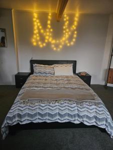 a bedroom with a bed with lights on the wall at Private room in Wellington with views in Wellington