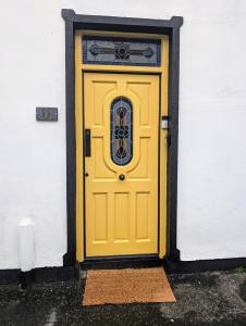 a yellow door on a white building at Ivy Townhouse Derry in Derry Londonderry