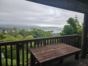 a wooden bench on a balcony with a view at Private room in Wellington with views in Wellington
