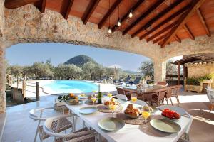 a dining room with a table and a swimming pool at Villa Alordes in Pollença