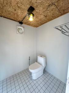 a bathroom with a toilet with a light on the ceiling at 385 Glamping in Ban Khai Nao (1) +18 photos