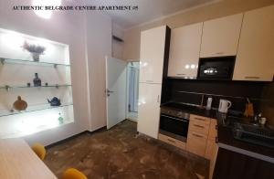 een keuken met witte kasten en zwarte apparaten bij Authentic Belgrade Centre - New Year 2026 - 2 Apartments for large Groups in one building in Belgrado