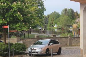 a car parked in a parking lot next to a river at Gästehaus INNFernow in Fürstenberg +1 photo