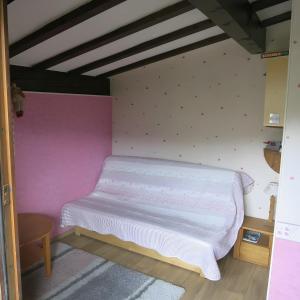 a bed in a room with a pink wall at Mon petit coin de paradis in Saint-Gervais-les-Bains